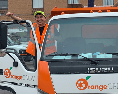 junk hauler in the truck smiling and showing thumbs up