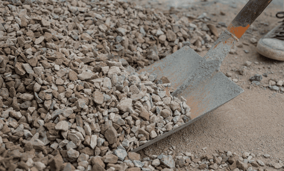 shovel and pile of landscaping rocks