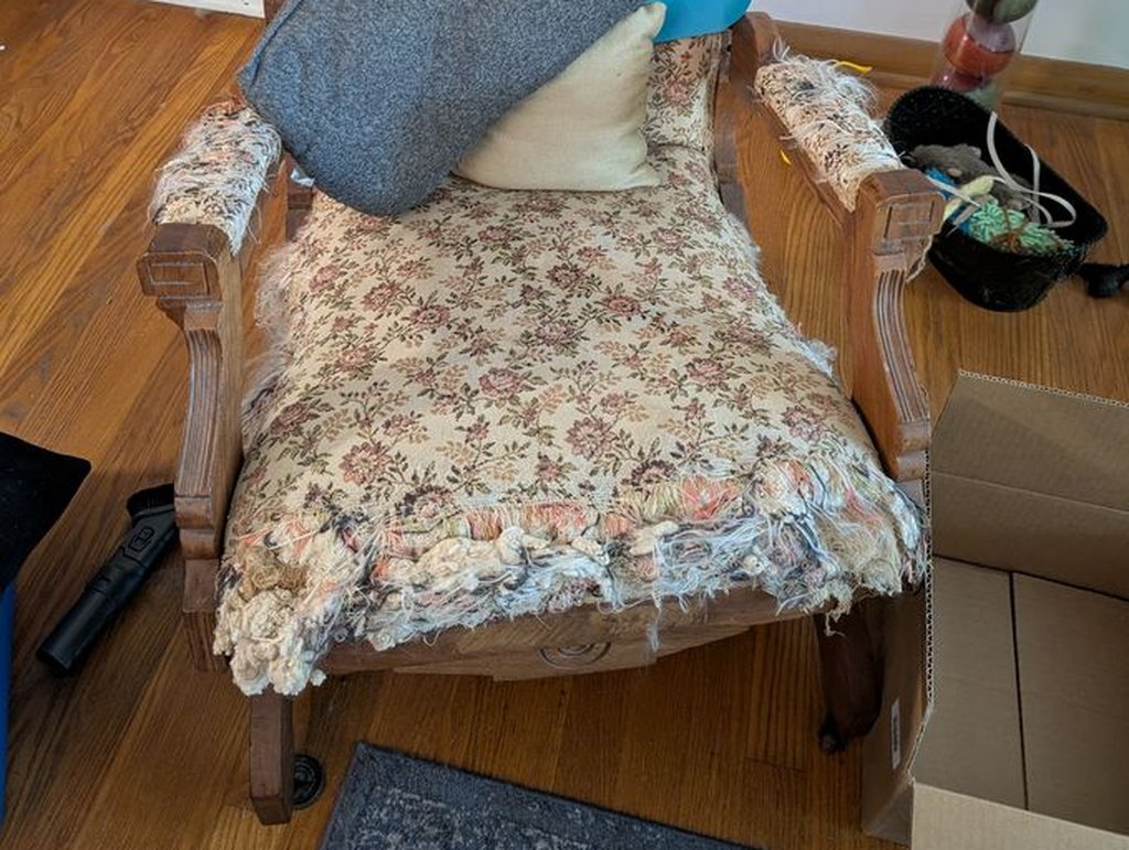 Carved wood antique armchair with torn floral upholstery removed during a Mundelein junk removal job