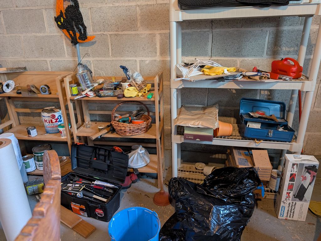 Garage shelving with paint cans, primer, toolboxes and a gas can during a garage clean-out