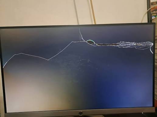 Computer monitor with a cracked screen set out for e-waste recycling pickup