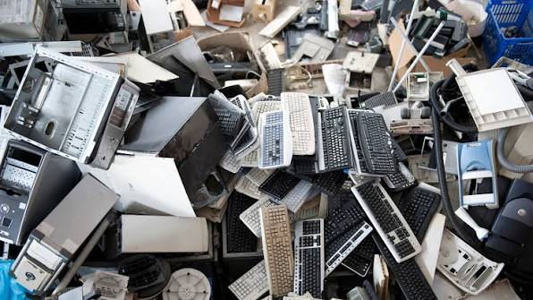 Pile of electronic waste including computers, keyboards, and monitors staged for certified recycling