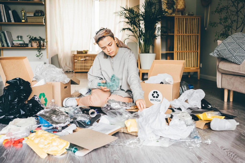 woman sitting around boxes and junk